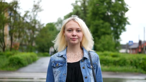 Retrato de joven hermosa chica rubia mirando a la cámara y sonriendo — Vídeo de stock