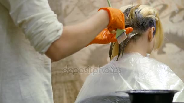 Hair-stylist makes hair color, blonde, dyes hair in blue. — Stock Video