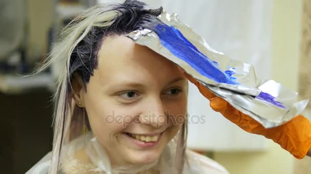 Cabelo-estilista faz a cor do cabelo, loira, tintura o cabelo em azul . — Vídeo de Stock