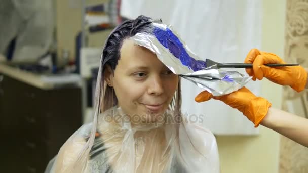 Cabelo-estilista faz a cor do cabelo, loira, tintura o cabelo em azul . — Vídeo de Stock