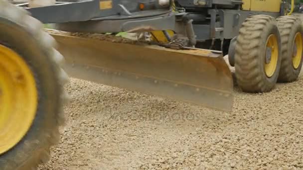 Excavadora de niveladora extendió la piedra triturada en la carretera — Vídeos de Stock