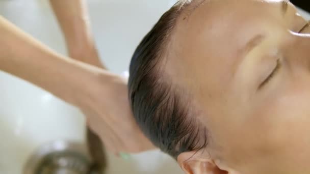 Полоскання клієнта волосся в салоні краси — стокове відео