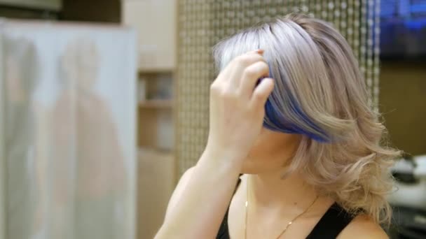 Mooie jonge vrouw controleren haar gezicht in de spiegel — Stockvideo