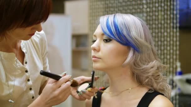 Profesional de maquillaje persona una joven con el pelo azul . — Vídeo de stock