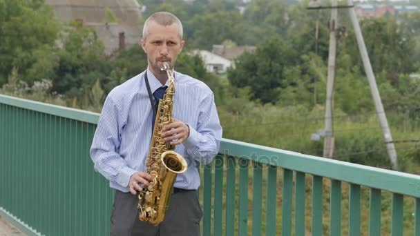 Саксофонист играет на саксофоне — стоковое видео