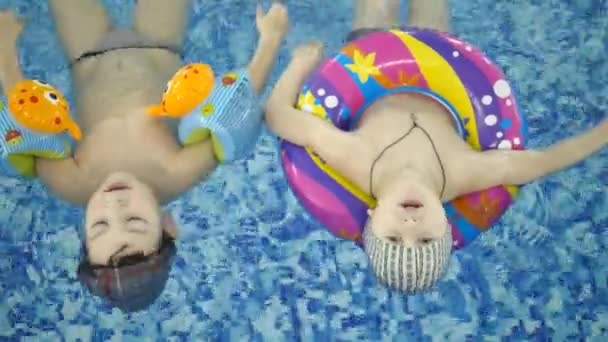 Giochi d'acqua per bambini in piscina. I bambini piccoli si fanno il bagno in piscina — Video Stock