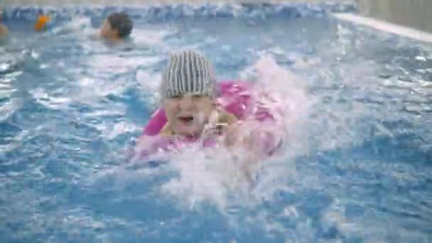 Jogos infantis de água na piscina. Crianças pequenas tomam banho na piscina — Vídeo de Stock