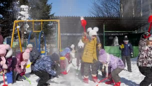 5 Μαρτίου 2018 τη Ρωσία, Οριόλ περιοχή, Μτσενσκ, editorial - τα παιδιά ρίχνουν το χιόνι με ένα φτυάρι. Παιδικά παιχνίδια εξωτερικού χώρου για το χειμώνα. Χαρούμενα παιδικά εταιρεία. — Αρχείο Βίντεο
