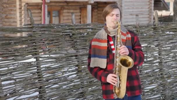 Hudebník hraje na saxofon, v zimě — Stock video