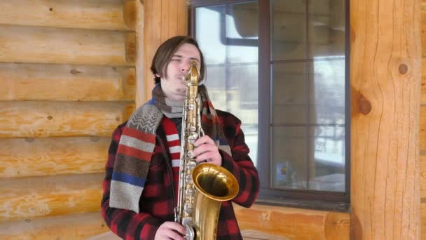 Saxofonist speelt de saxofoon, in de winter — Stockvideo