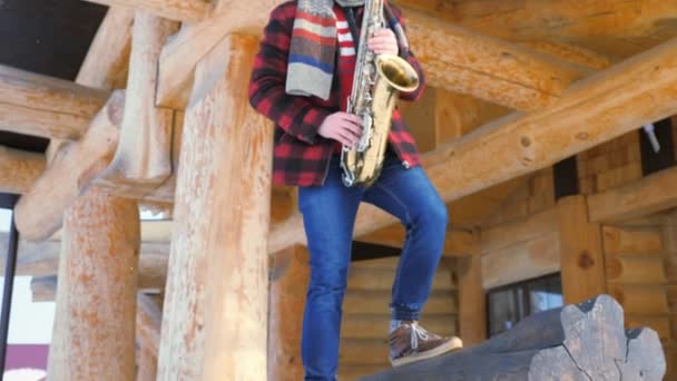 Саксофонист играет на саксофоне зимой — стоковое видео