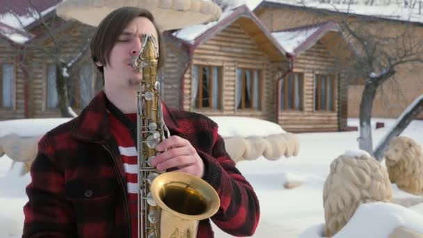 Saxofonist spelar saxofon, vintertid — Stockvideo