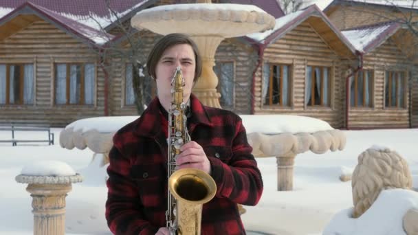 Saxofonista toca saxofone, no inverno — Vídeo de Stock