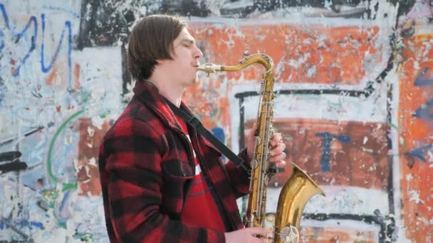 Саксофоніст грає на саксофоні, взимку — стокове відео