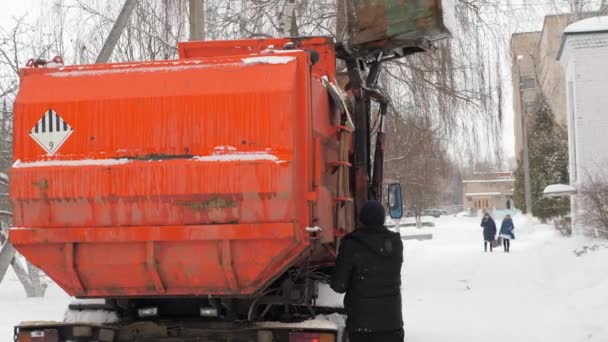 Работать на мусорных машинах зимой. Автомобиль для перевозки мусора загружается сам . — стоковое видео