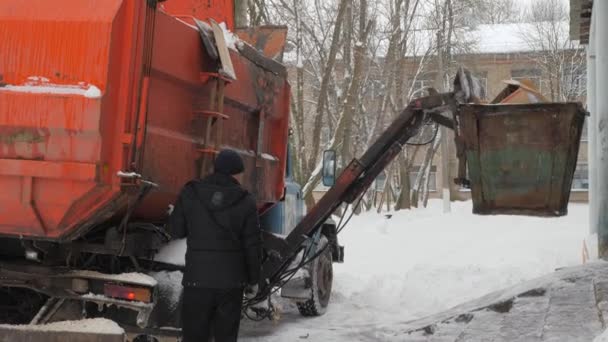 겨울에 쓰레기 차를 작동 합니다. 쓰레기 수송 차 자체를 로드. — 비디오