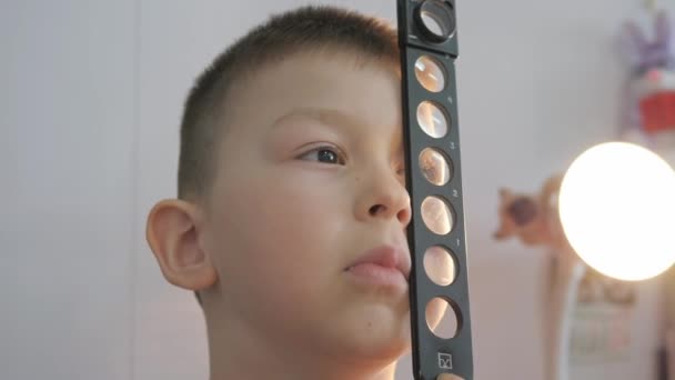 Child in an ophthalmic clinic. Checking visual acuity with a line of ski-like — Stock Video