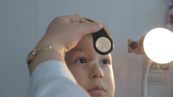 Bambino in una clinica oftalmica. Esame del fondo oculare dei bambini con una lente d'ingrandimento . — Video Stock