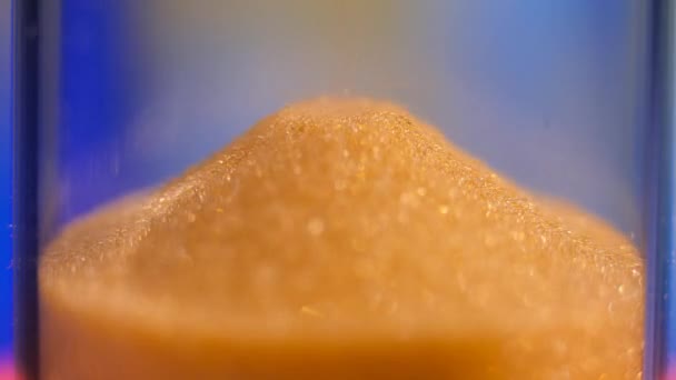 Zandloper. Super Close-up weergave van zand die door een zandloper stroomt. — Stockvideo