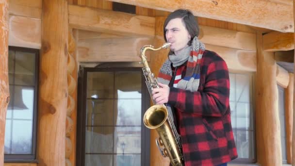 Саксофоніст грає на саксофоні, взимку — стокове відео