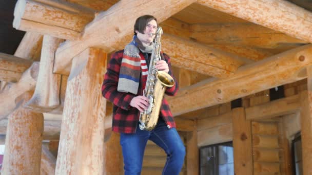 Saxophoniste joue du saxophone, en hiver — Video