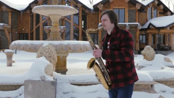 Saxofonist speelt de saxofoon, in de winter — Stockvideo