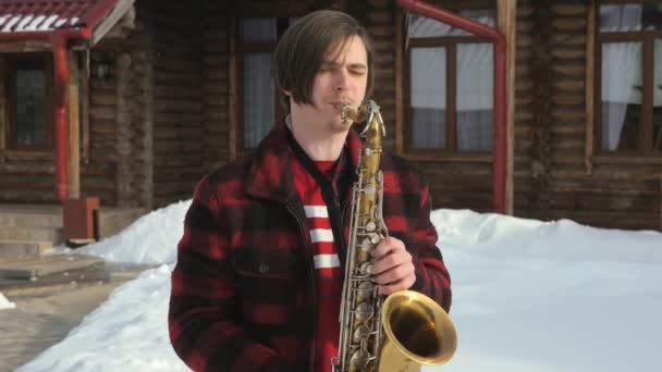 Saxofonista toca saxofone, no inverno — Vídeo de Stock