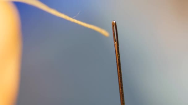 Rosca el ojo de una aguja. Tirando del hilo en el ojo de la aguja de coser . — Vídeos de Stock