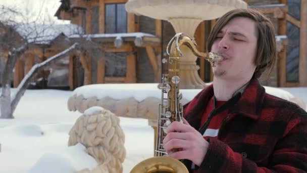 Saxofonista toca el saxofón, en invierno — Vídeos de Stock