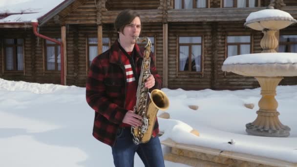 Saxofonista toca saxofone, no inverno — Vídeo de Stock