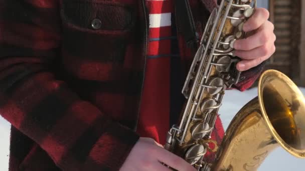 Saxofonista toca el saxofón, en invierno — Vídeo de stock