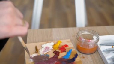 Sanatçı doğadan bir portre çizer. Sanatçı doğadan bir portre çizer. Kayan kamera odaklama, kamera çekimde. Scarlet peonies oturan poz kafasında bir çelenk ile güzel model