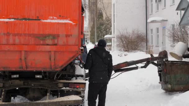 Працюють сміттєві машини взимку. Сміттєвоз самостійно завантажує автомобіль . — стокове відео