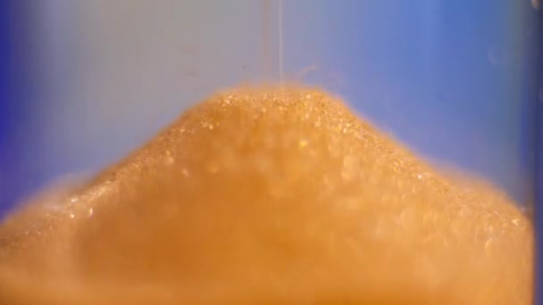 Sanduhr. Super Nahaufnahme von Sand, der durch eine Sanduhr fließt. — Stockvideo