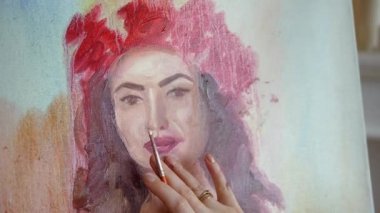 Sanatçı doğadan bir portre çizer. Sanatçı doğadan bir portre çizer. Kayan kamera odaklama, kamera çekimde. Scarlet peonies oturan poz kafasında bir çelenk ile güzel model