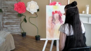 Sanatçı doğadan bir portre çizer. Sanatçı doğadan bir portre çizer. Kayan kamera odaklama, kamera çekimde. Scarlet peonies oturan poz kafasında bir çelenk ile güzel model