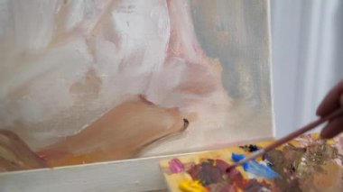 Sanatçı doğadan bir portre çizer. Sanatçı doğadan bir portre çizer. Kayan kamera odaklama, kamera çekimde. Scarlet peonies oturan poz kafasında bir çelenk ile güzel model