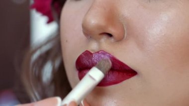 Makyaj sanatçı stilist modeli ile çalışır. Makyaj Güzellik Salonu bir genç kız. model yüzünde makyaj kullanan makyaj sanatçısı. Esmer kadın oturur sanatçı ile çalışsa da