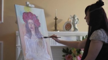 Sanatçı doğadan bir portre çizer. Sanatçı doğadan bir portre çizer. Kayan kamera odaklama, kamera çekimde. Scarlet peonies oturan poz kafasında bir çelenk ile güzel model