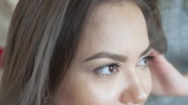 Makyaj sanatçı stilist modeli ile çalışır. Kuaför saç şekillendirme modeli yapar. kadın saç bakım genç kadın uzun saçlı kız İlaçlama. koyu renk gözlü bir kız yakın çekim