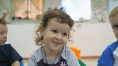 Çocuk Oyun Odası geliştirmek. Sınıflar eğlenceli sırasında duygular genç çocuk. Çocuk üst üste sandalyelere oturmak. Çocuk bir neşeli ifade inşa ediyor. Palyaçoluk ve smeyotsya eğlenceli.