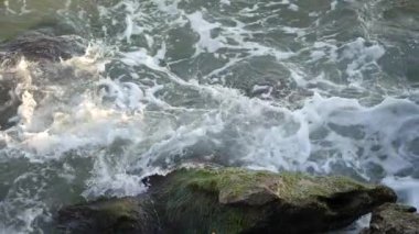 Dalgalar kıyıda kırılır. Dalgalar kayalarda kırılır.