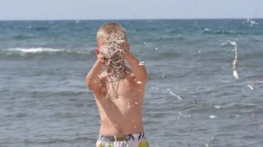 Plaj yaz tatili. Çocukların duyguları işte. Çocuk rüzgârda parıldıyor..
