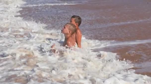 Sommerurlaub am Strand. Kinder in den wütenden Wellen. — Stockvideo