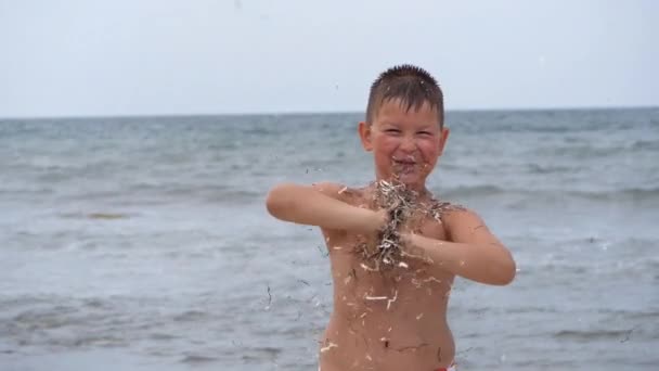 Vacaciones de verano en playa. Emociones de los niños. El niño desarrolla oropel en el viento . — Vídeos de Stock