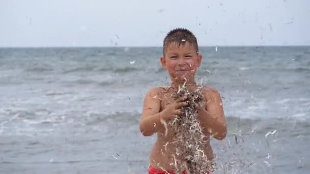 Летние каникулы на пляже. Детские эмоции. Ребенок развивает мишуру на ветру . — стоковое видео