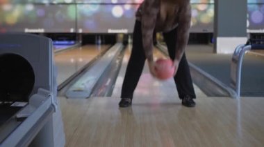 Bowling 'de zaman geçirmek. Pistte paten yapan toplar lobutları devirmek için..