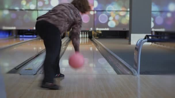 Zábava v bowlingu. Bruslení míče na trati s cílem srazit kolíky. — Stock video