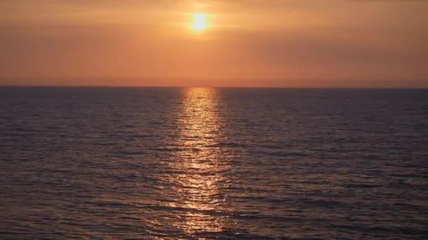 海の中の赤い夕日 緋色の夕日 太陽は地平線から昇る — ストック動画