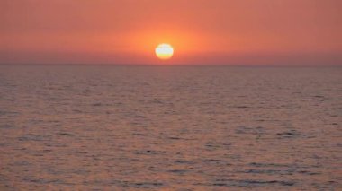 Denizde gün batımı. Kızıl günbatımı. Güneş ufuktan doğuyor..